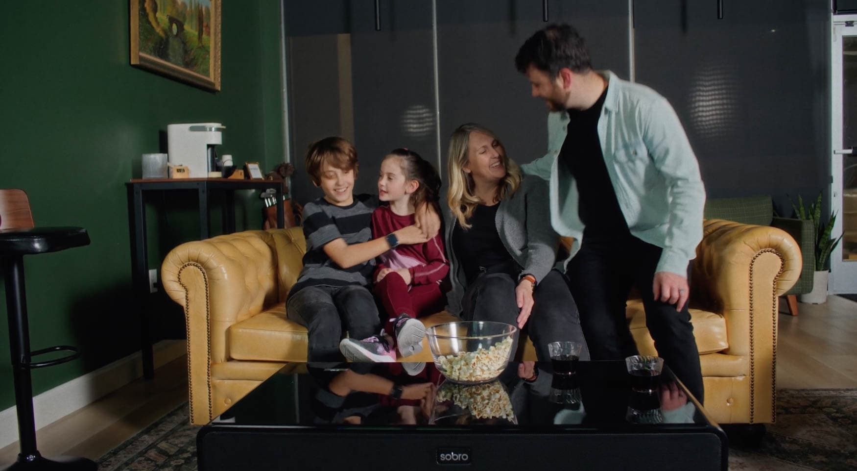 Family relaxing on a Chesterfield sofa in the Rev's Golf Lounge seating area