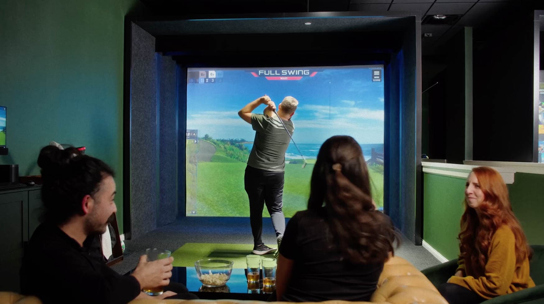 Groups mingling in the lounge area between simulator bays at Rev's Golf Lounge