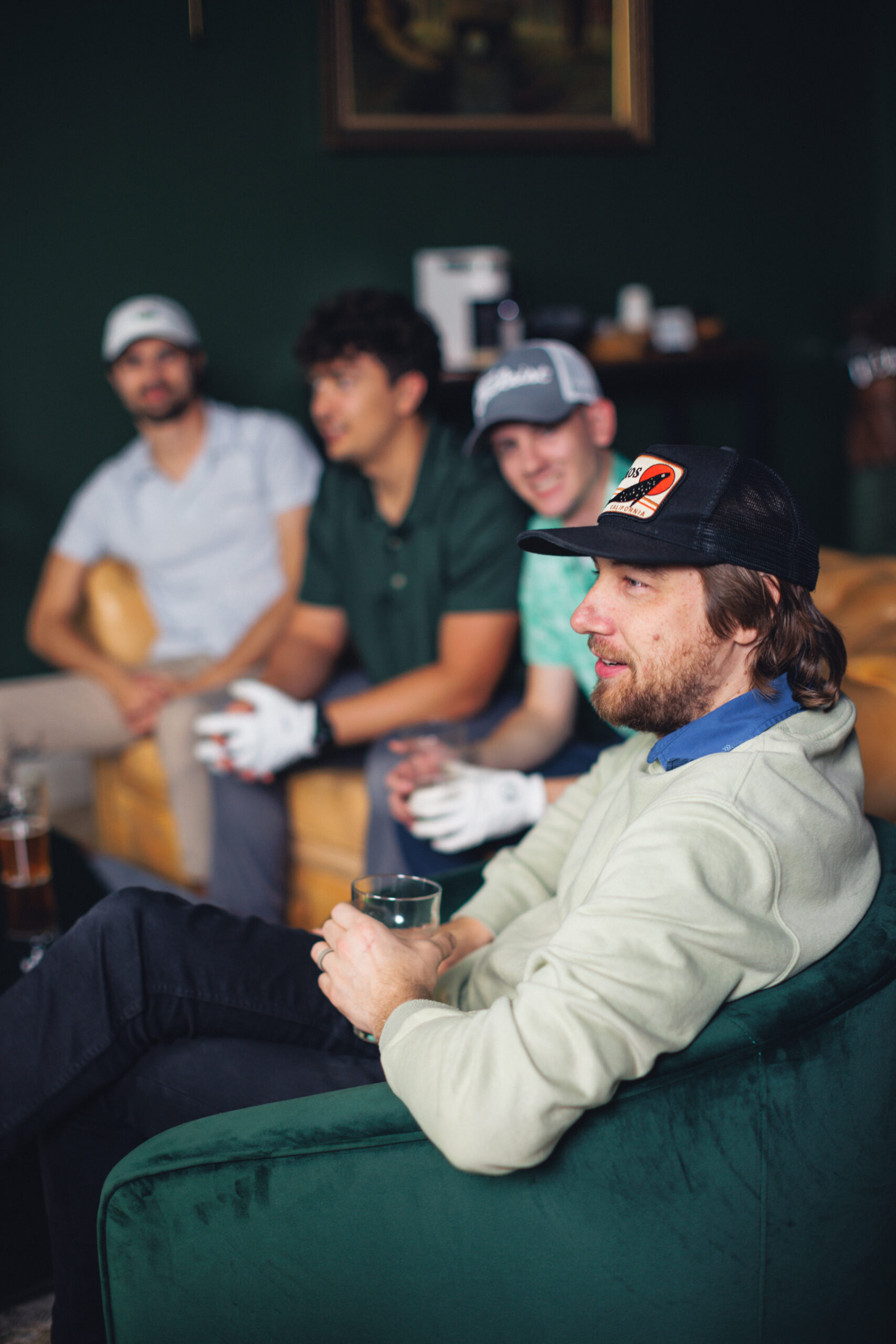 friends drink beers while onlooking game of luxury indoor golf